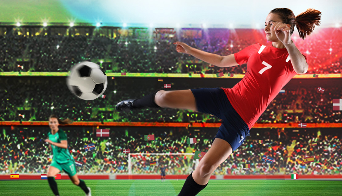 Footballer in a red number 7 kit kicking a ball in a floodlit stadium.